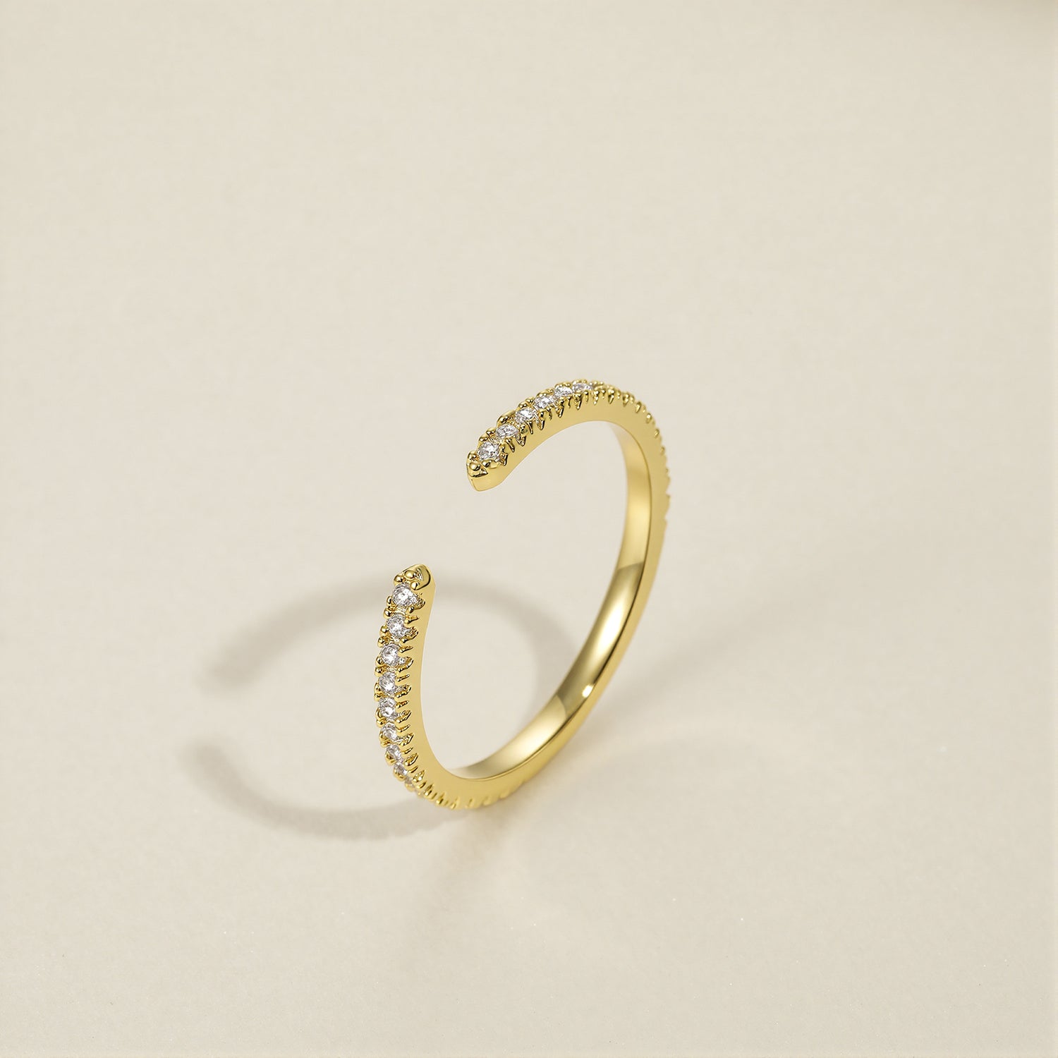 unusual womens wedding bands​, 5A CZ band ring, modern promise ring, cubic zirconia Rings, cz ring, wedding rings cz, eamti rings, cheap wedding rings under $50, copper ring, open band rings, open wedding band​. Gold open ring with small diamonds on a beige background